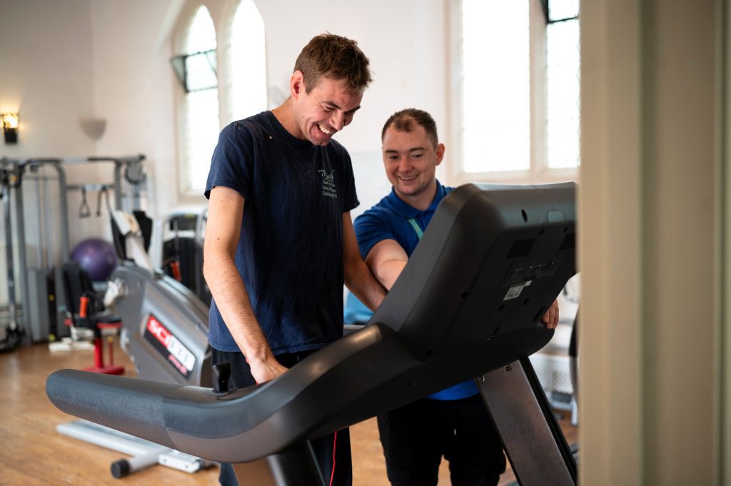 Chris being supported to use the Gym treadmill