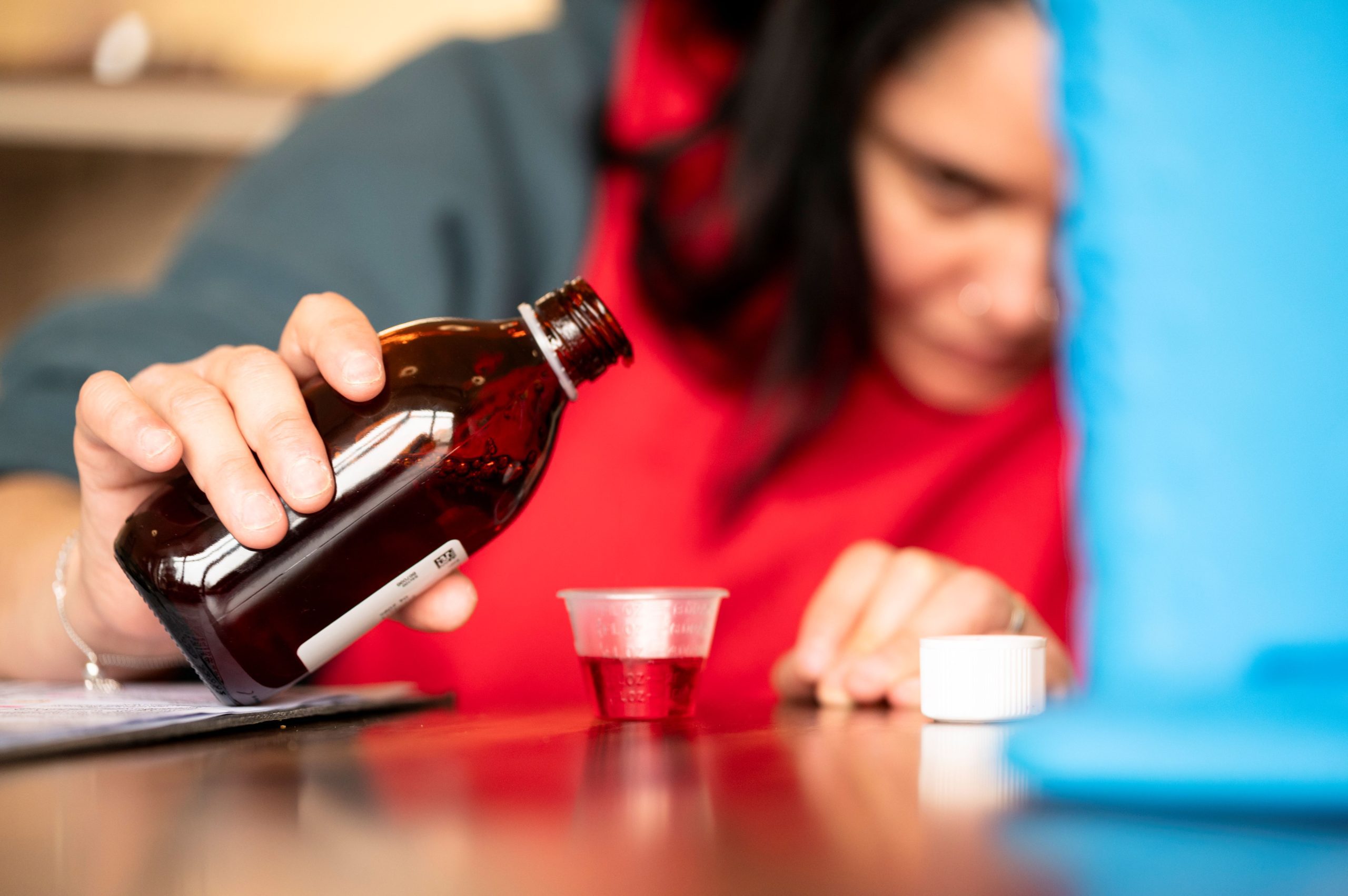 A Support Worker carefully measuring out liquid medication