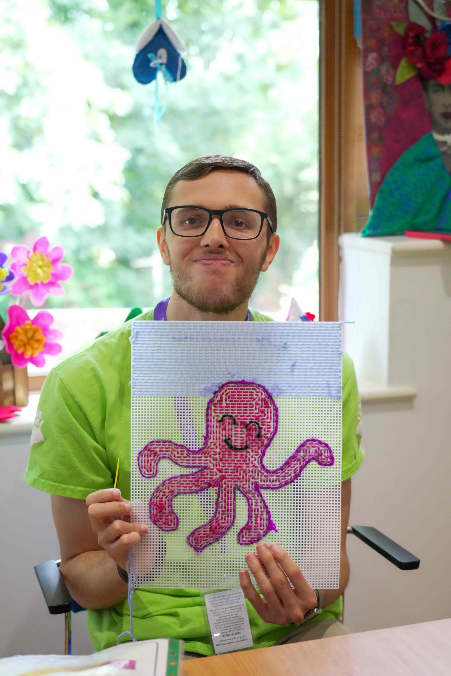 Nathan proudly showing his purple octopus needlework creation