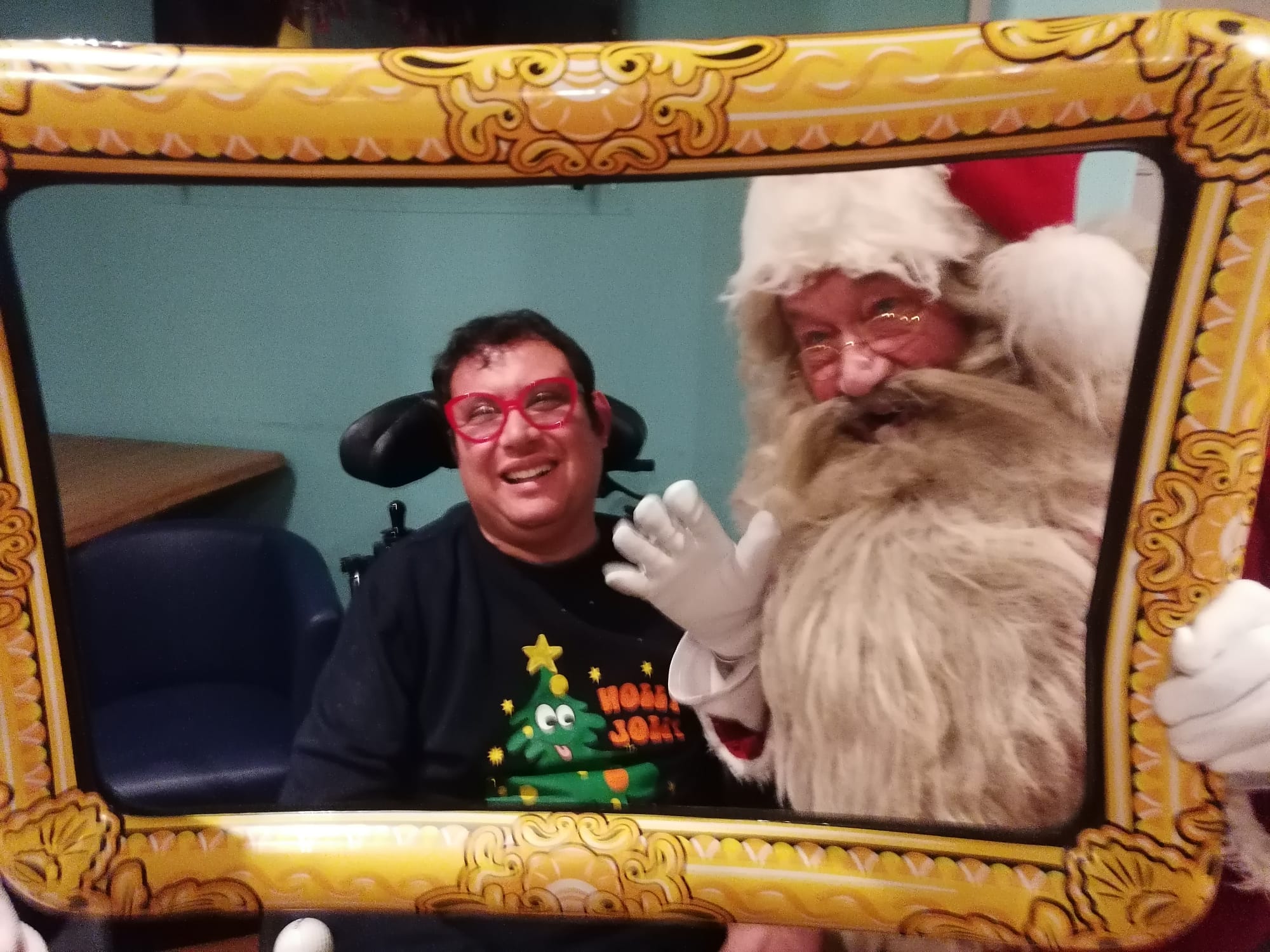 Santa featured posing with a selfie frame next to Dom, who is smiling and is wearing his Christmas Jumper.