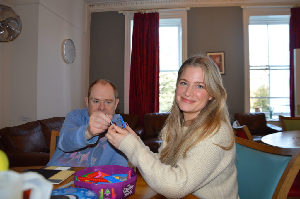 Service Manager Jordan supporting John with lego building.