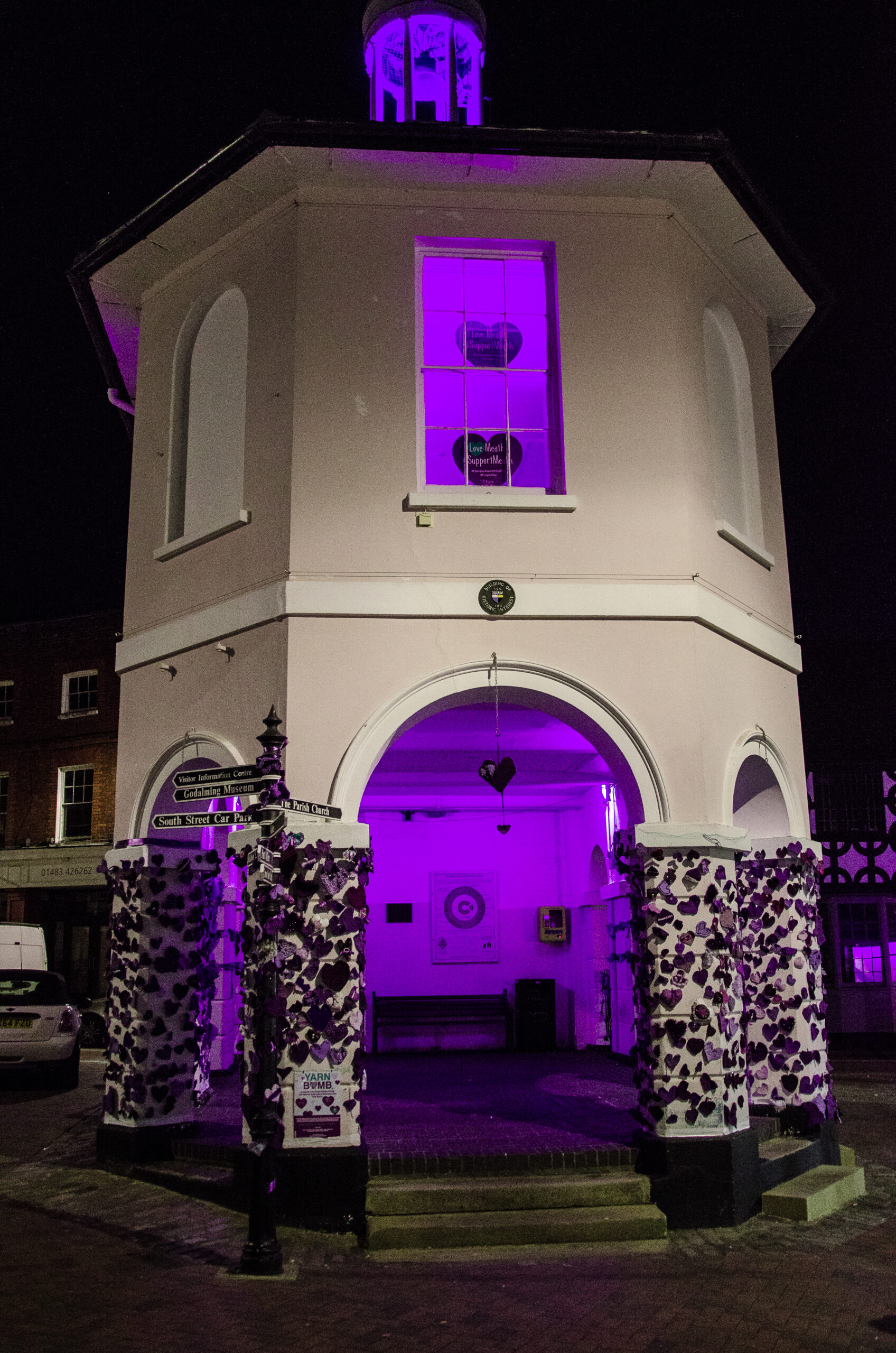 Godalming's Pepperpot building lit purple against the night's sky.